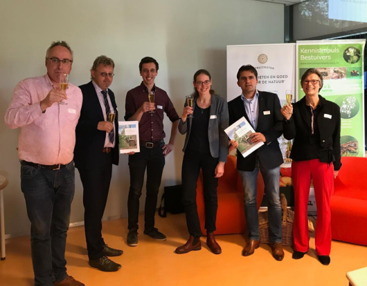 Op de foto van links naar rechts: Henri Holster (bestuurder De Fruitmotor), gedeputeerde Peter Drenth, Arjen de Groot (WUR), Jeltje Stam (WUR), Gerard van den Anker (NFO) en Hilde Engels (bestuurder De Fruitmotor) brengen een toast uit op de presentatie van het boek met een glas Krenkelaar.